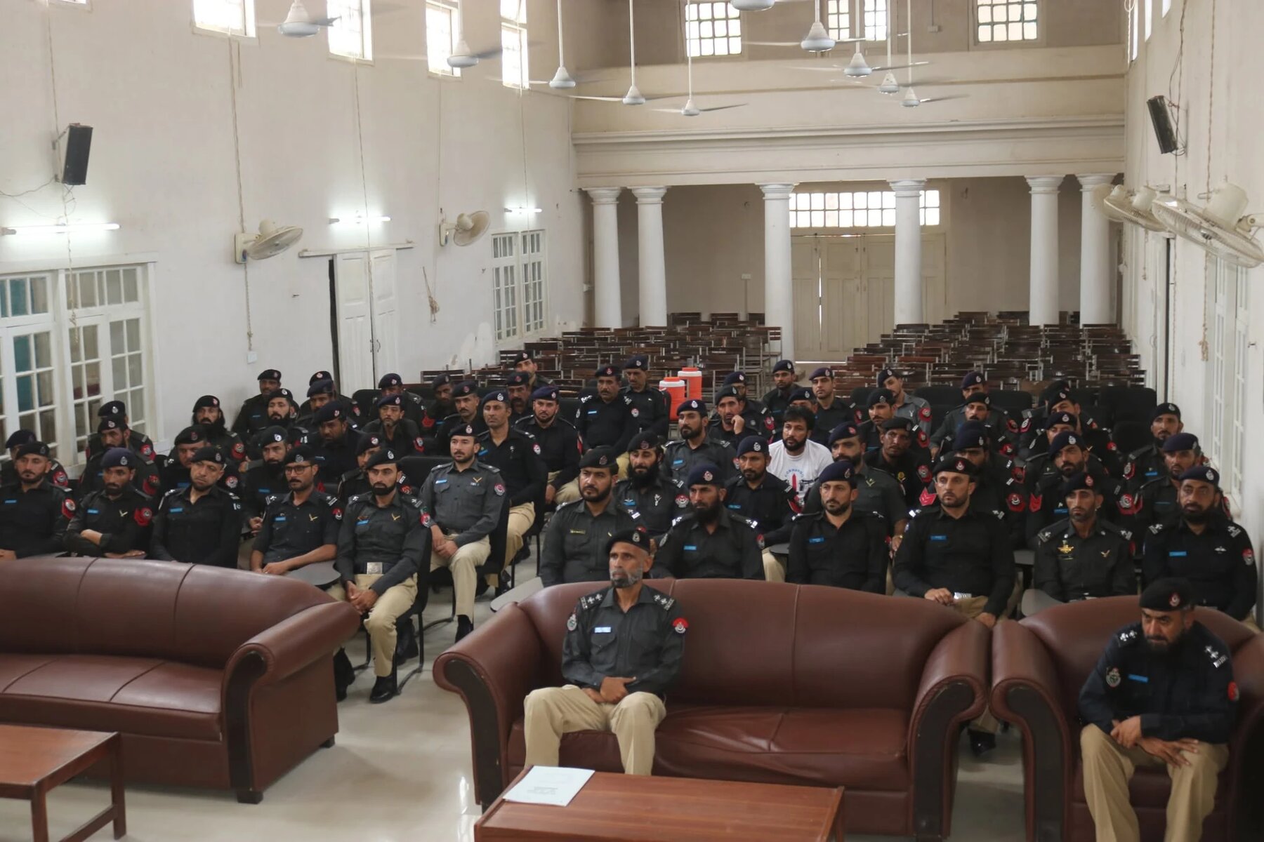 Officers assembled in a training hall at Police Training College Hangu